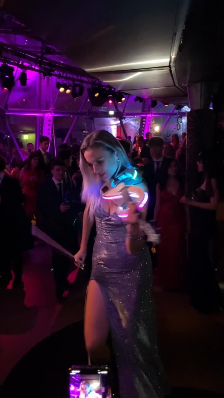 LED violin performer playing for guests on a colorful dance floor.